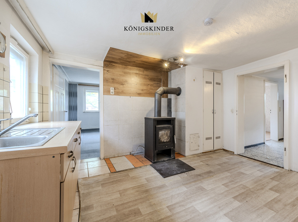 Küche mit Holzeinzelofen – Renovierungspotenzial.
