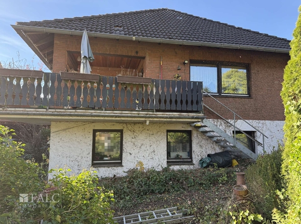 Blick vom Garten auf die teilüberdachte Balkonterrasse