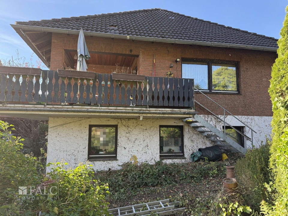 Blick vom Garten auf die teilüberdachte Balkonterrasse