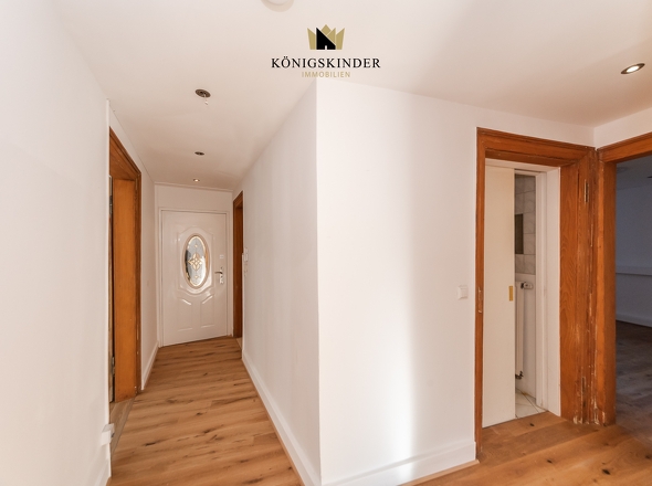 Einladender Eingangsbereich – warme Holzoptik und klare Linien führen in die charmanten Wohnräume