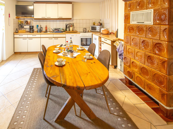 EG Wohnküche mit Kachelofen und Ausgang zur Terrasse