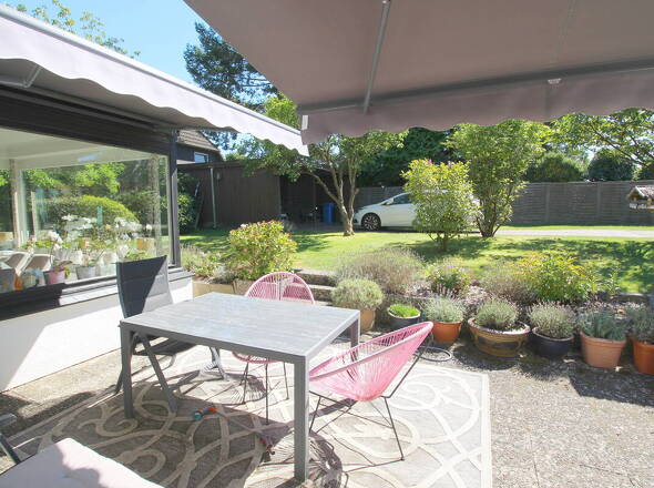 Blick auf Terrasse mit 2 Markisen, Carport u. Wintergarten