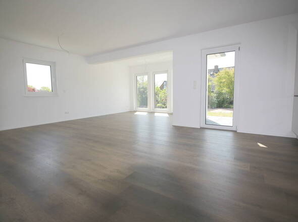 Blick in den Wohnbereich mit bodentiefen Fenstern u. Terrassenzugang