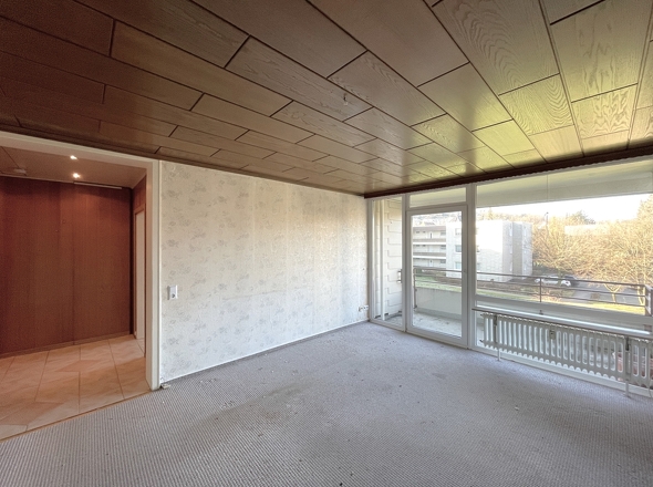 Wohnzimmer mit großer Fensterfront zum Sonnenbalkon 