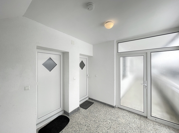 Freundlicher Treppenhausflur mit modernen Wohnungstüren