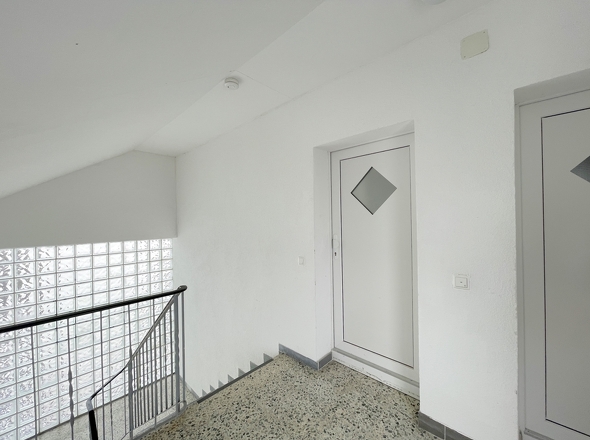Freundlicher Treppenhausflur mit modernen Wohnungstüren