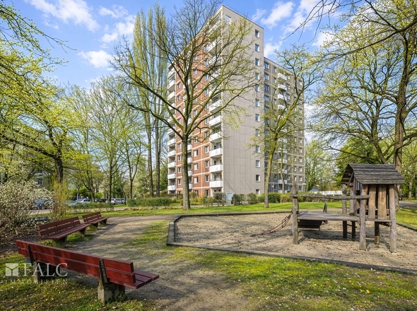 Gebäude komplett mit Spielplatz im Frühling