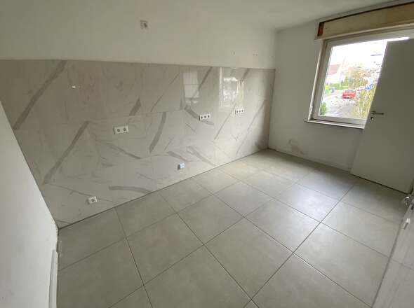 Küche mit großformatigen Wand- und Bodenfliesen