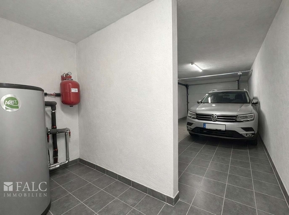 „Garage mit separatem Heizungsraum, aktuell baubedingt mit Material belegt – Visualisierung.“