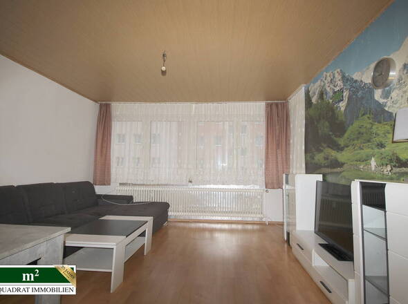 Wohnzimmer mit Panoramafenster und Loggiazugang