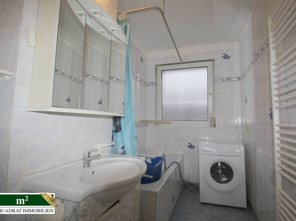 Badezimmer mit Wanne und Waschmaschine