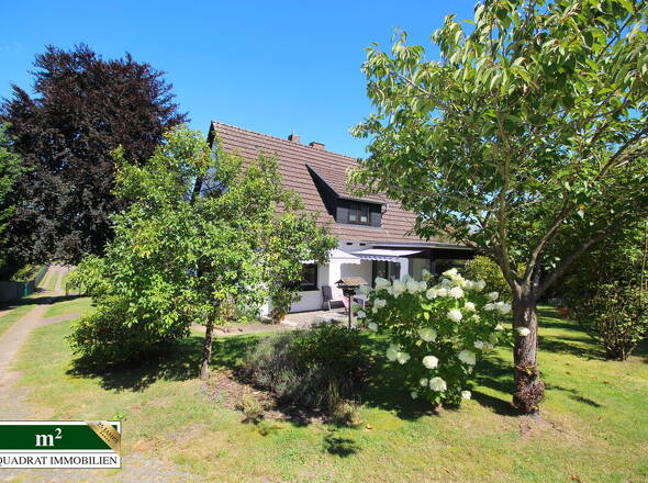 Gartenperspektive auf EFH und großzügige Zufahrt