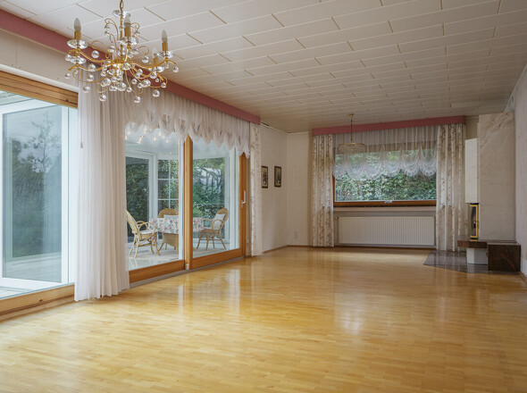 Das Wohnzimmer mit Kamin und dem Wintergarten