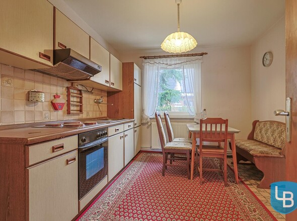 Küche mit älteren Einbauten und Sitzmöglichkeit