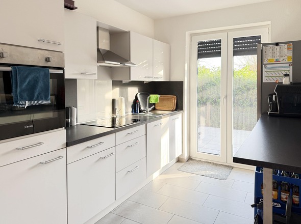 Küche mit moderner Einbauküche und Zugang zur Terrasse