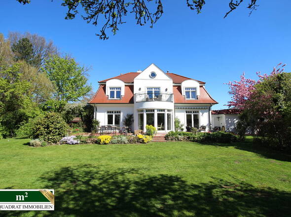 Gartenseitiger Blick auf die Villa mit Mansarddach