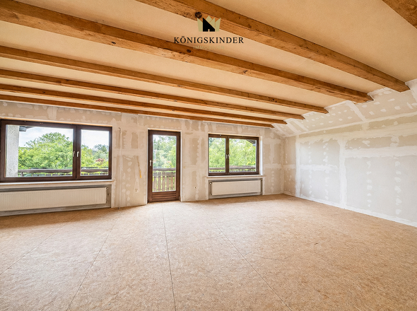 Großzügige Ausbaureserve mit Balkon und sichtbaren Holzbalken