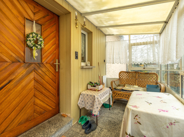Hauseingangstür über Veranda mit Sitzecke