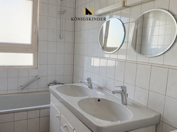 Badezimmer mit Wanne und Doppelwaschbecken.