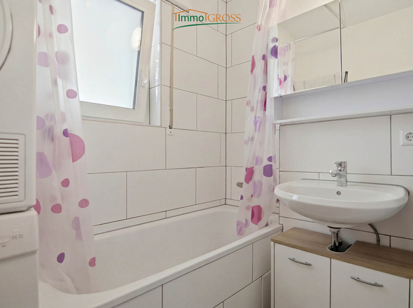 Badezimmer mit Badewanne und Waschmaschinenanschluss