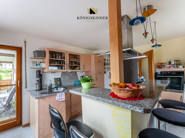 EG: Küche mit Kücheninsel und direktem Zugang zum Balkon und in den Garten