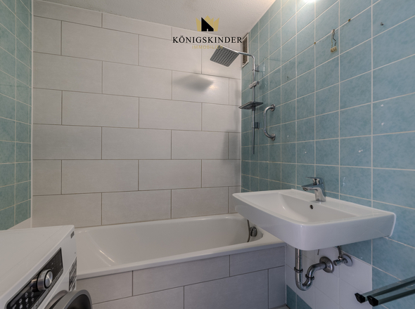 Funktional ausgestattetes Badezimmer mit zusätzlichem Waschmaschinenstellplatz.