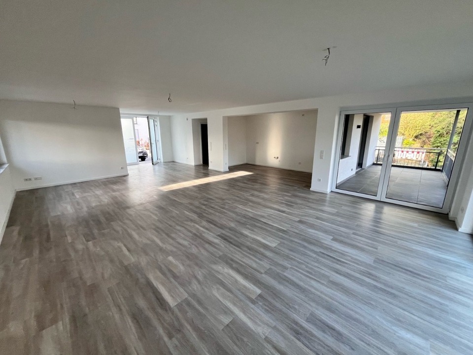 großzügiger Wohnraum mit offener Küche und Zugang zur Loggia