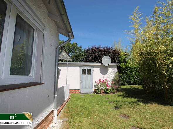 Gartenblick auf Garage mit Nebeneingang
