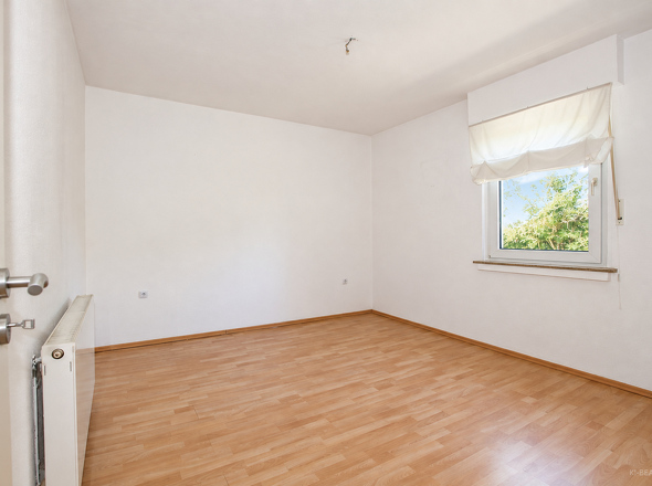 Zimmer mit Fenster und Holzboden
