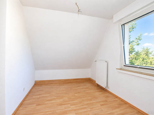Zimmer mit Dachschräge und großem Fenster