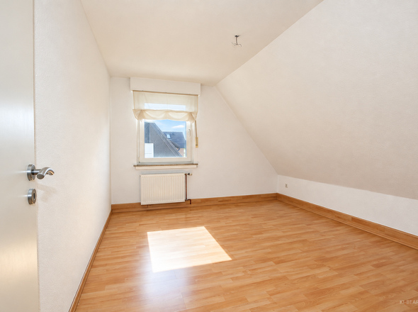 Zimmer mit Dachschräge und Holzboden